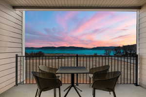 Balcony at dusk featuring a Bear Lake and mountain view