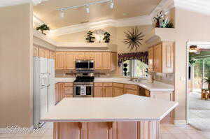 Kitchen featuring track lighting, stainless steel appliances, light tile patterned flooring, and light brown cabinets