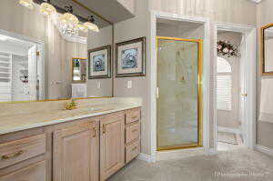 Full bathroom featuring vanity, a stall shower, and baseboards