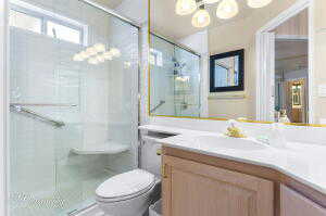 Full bathroom featuring vanity, toilet, a notable chandelier, and a stall shower