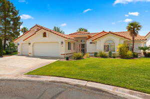 Mediterranean / spanish-style house featuring a tile roof, a front lawn, stucco siding, driveway, and an attached garage