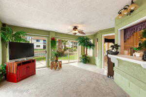 Carpeted living room with a ceiling fan