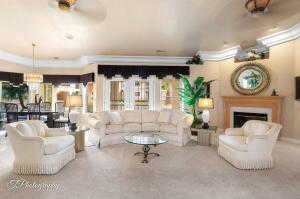 Carpeted living room with a fireplace and crown molding