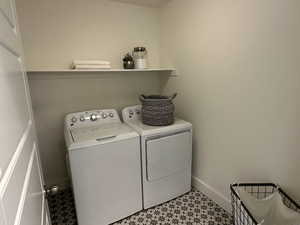 Laundry room featuring light floors, baseboards, laundry area, and independent washer and dryer