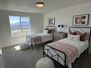 Carpeted bedroom featuring visible vents, baseboards, a textured ceiling, and a mountain view