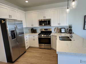 Kitchen with white cabinetry, stainless steel appliances, and a sink