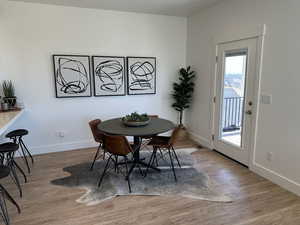 Dining space with wood finished floors, visible vents, and baseboards