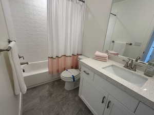 Full bathroom featuring shower / bath combination with curtain, vanity, and toilet