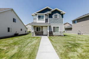 Craftsman-style house with central air condition unit, stone siding, and a front lawn