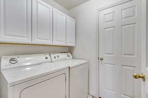 Laundry area with cabinet space and washing machine and clothes dryer