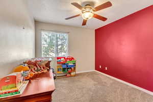Playroom featuring a ceiling fan, baseboards, and carpet