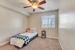 Bedroom featuring baseboards, carpet flooring, and ceiling fan