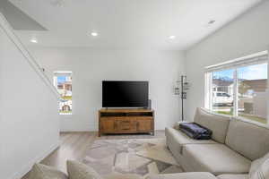Living room featuring visible vents, light wood-style flooring, baseboards, and recessed lighting