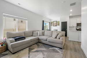 Living room featuring recessed lighting, visible vents, and light wood-type flooring