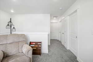 Living area featuring baseboards, visible vents, and carpet