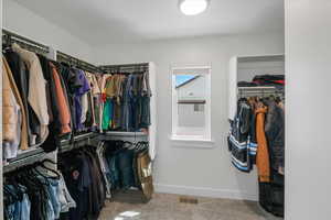 Spacious closet with visible vents and carpet flooring