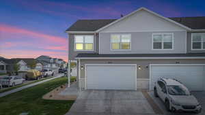 Exterior space featuring a garage, a residential view, side yard, and concrete driveway