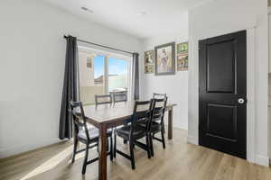 Dining space featuring baseboards, visible vents, and light wood-type flooring