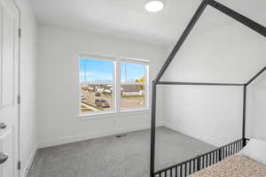 Unfurnished bedroom with carpet floors, visible vents, and baseboards