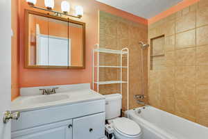 Bathroom with toilet, vanity, and shower / tub combination