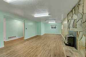 Basement with baseboards, wood finished floors, and visible vents