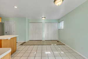 Unfurnished bedroom featuring light tile patterned floors, baseboards, and two closets