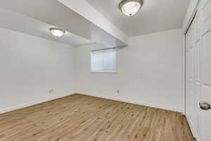 Unfurnished bedroom with baseboards, a closet, and light wood-style flooring