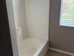 Bathroom featuring baseboards and tile patterned flooring