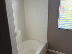Bathroom featuring tub / shower combination, tile patterned floors, and baseboards