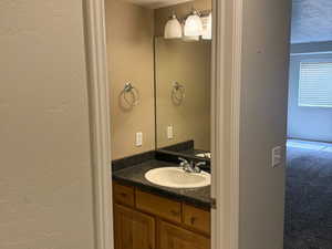Bathroom featuring a textured ceiling, tile patterned floors, and vanity