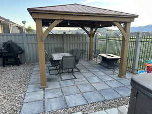 View of patio / terrace with area for grilling, a fenced backyard, outdoor dining space, a gazebo, and a mountain view