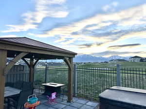 View of patio / terrace featuring a gazebo, an outdoor fire pit, fence, and a mountain view