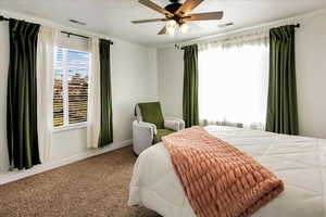 Bedroom featuring carpet floors, visible vents, a ceiling fan, and baseboards