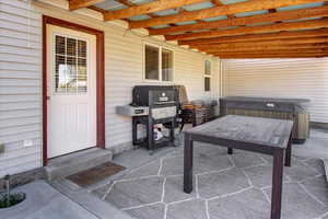 View of patio with a hot tub and entry steps