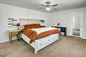 Bedroom featuring light colored carpet, baseboards, and a ceiling fan