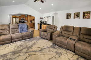 Living area with arched walkways, a ceiling fan, light tile patterned floors, and recessed lighting