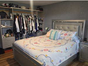 Bedroom with wood finished floors and a closet