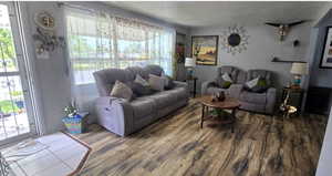 Living area with plenty of natural light, wood finished floors, and a textured ceiling