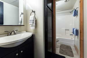 Full bathroom with toilet, vanity, and shower / washtub combination