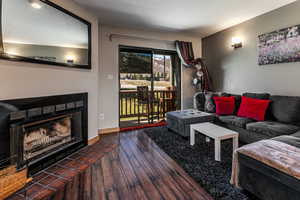 Living area featuring baseboards, wood finished floors, and a tile fireplace