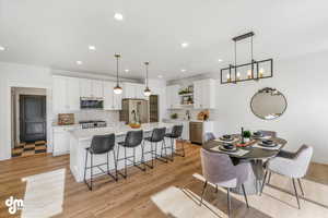 Dining area featuring light wood-type flooring, an inviting chandelier, and recessed lighting