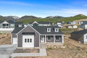 View of front of property featuring a residential view, driveway, covered porch, and a mountain view