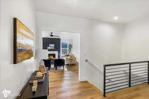 Hallway with recessed lighting, baseboards, an upstairs landing, and light wood-type flooring