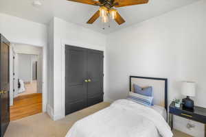 Bedroom featuring baseboards, a closet, and light colored carpet