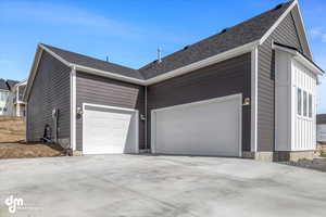 View of home's exterior with a garage and concrete driveway