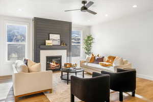 Living room featuring recessed lighting, a ceiling fan, light wood-style floors, and a fireplace