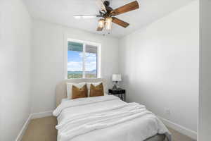 Carpeted bedroom featuring baseboards and ceiling fan