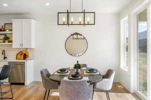 Dining room featuring light wood-style flooring, baseboards, and a healthy amount of sunlight