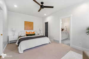 Bedroom featuring ensuite bathroom, light colored carpet, baseboards, visible vents, and recessed lighting