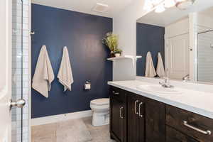 Full bath featuring toilet, baseboards, visible vents, tile patterned flooring, and vanity